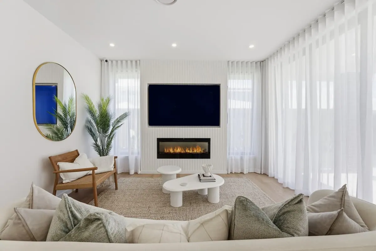 Staged living room with the fireplace on, warm and bright