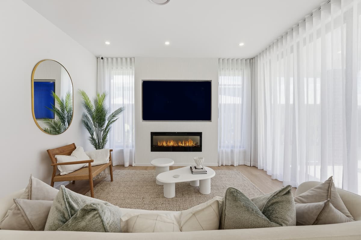 Staged living room with the fireplace on, warm and bright